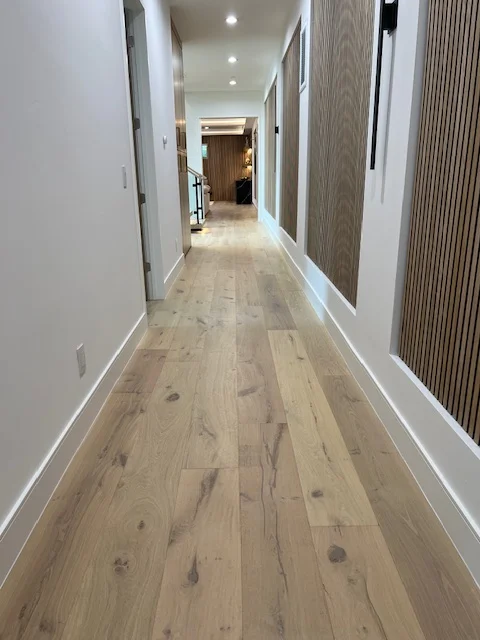 Modern hallway with light oak hardwood flooring and white trim work