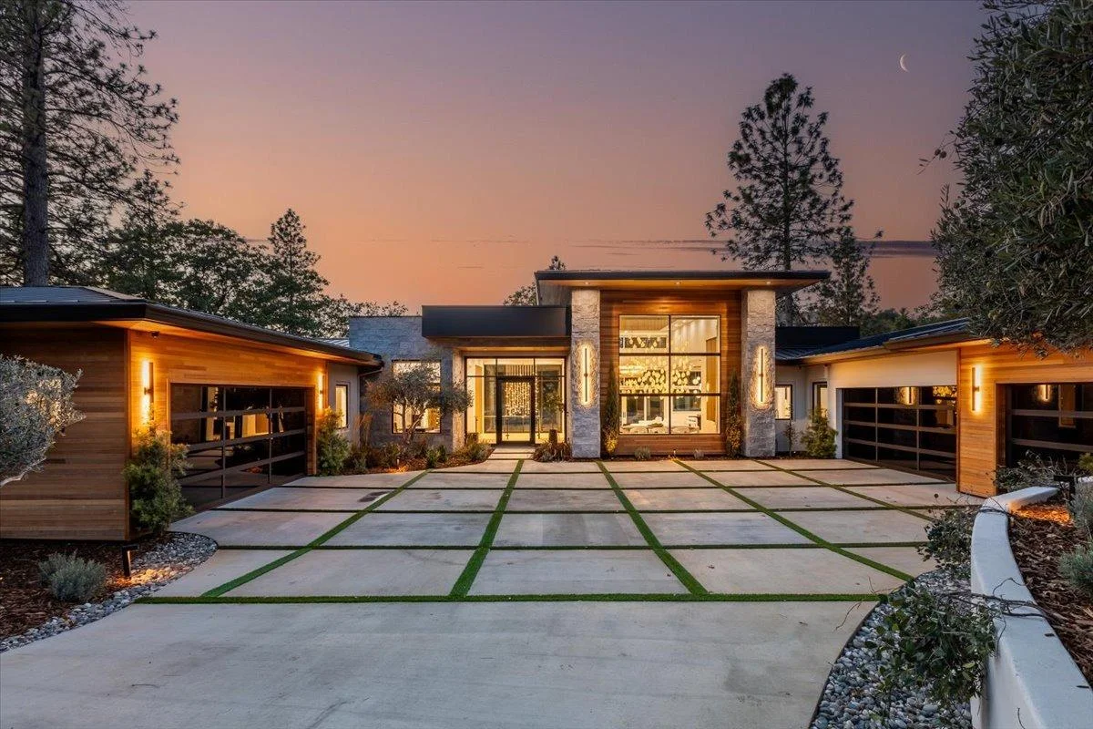 Modern concrete paver driveway with grass strips at contemporary home at dusk